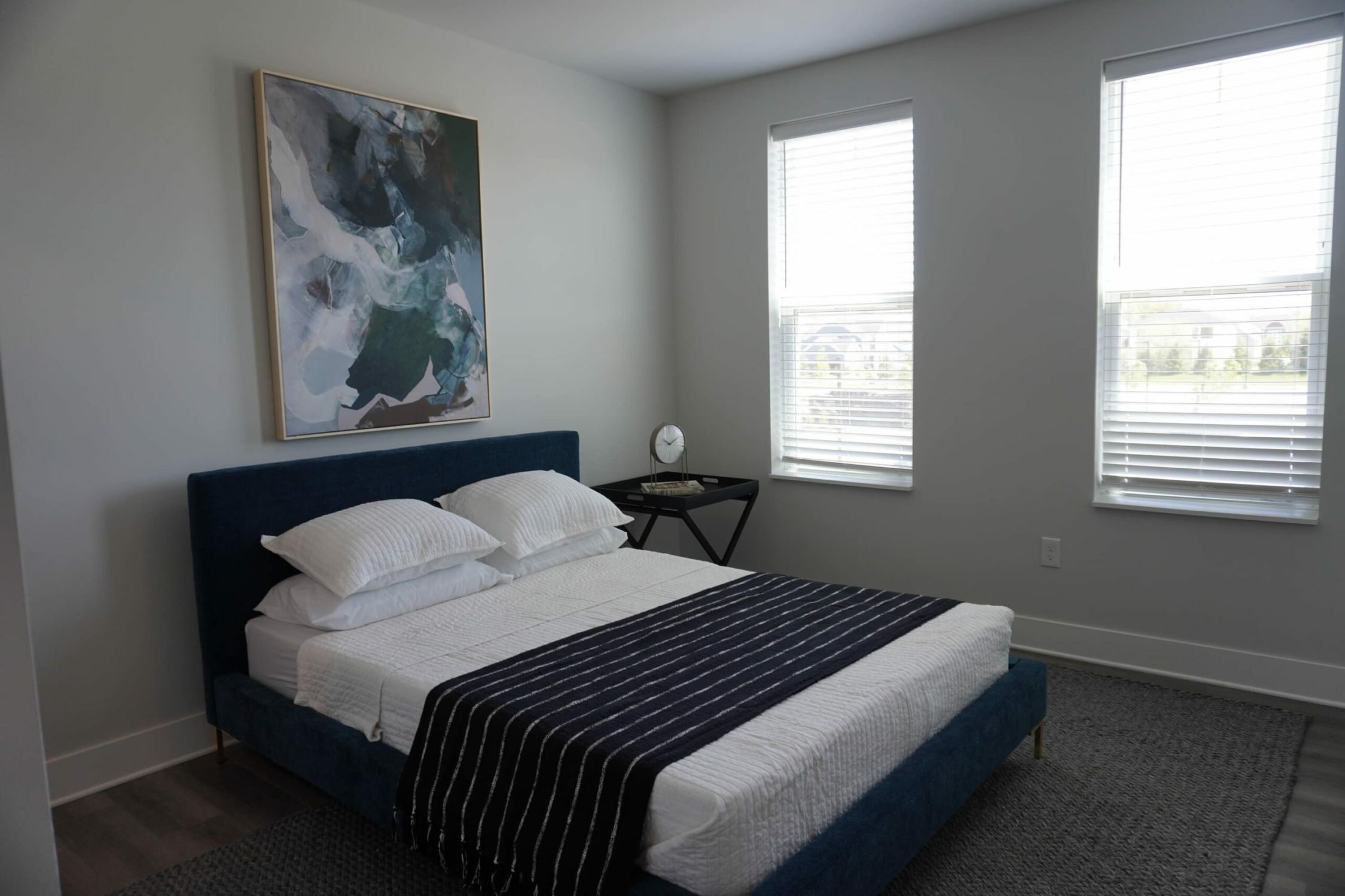 A bedroom with a bed and a painting on the wall.