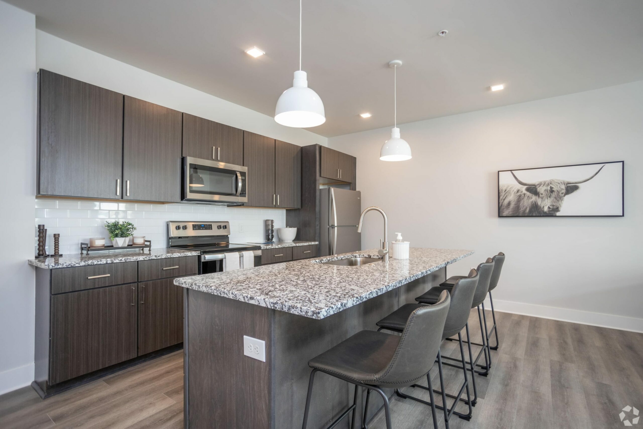 A kitchen with granite counter tops and stainless steel appliances.