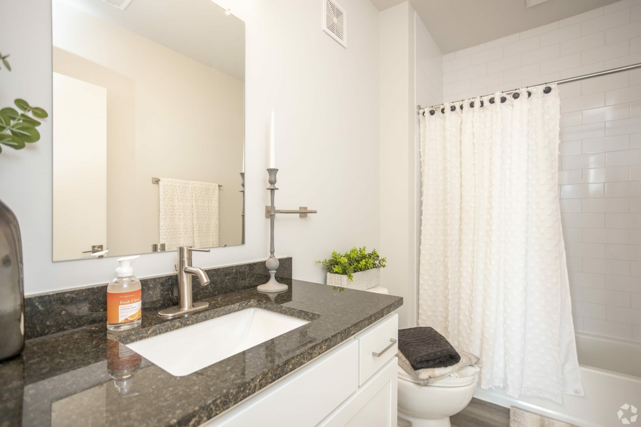 A bathroom with granite counter tops and a sink.