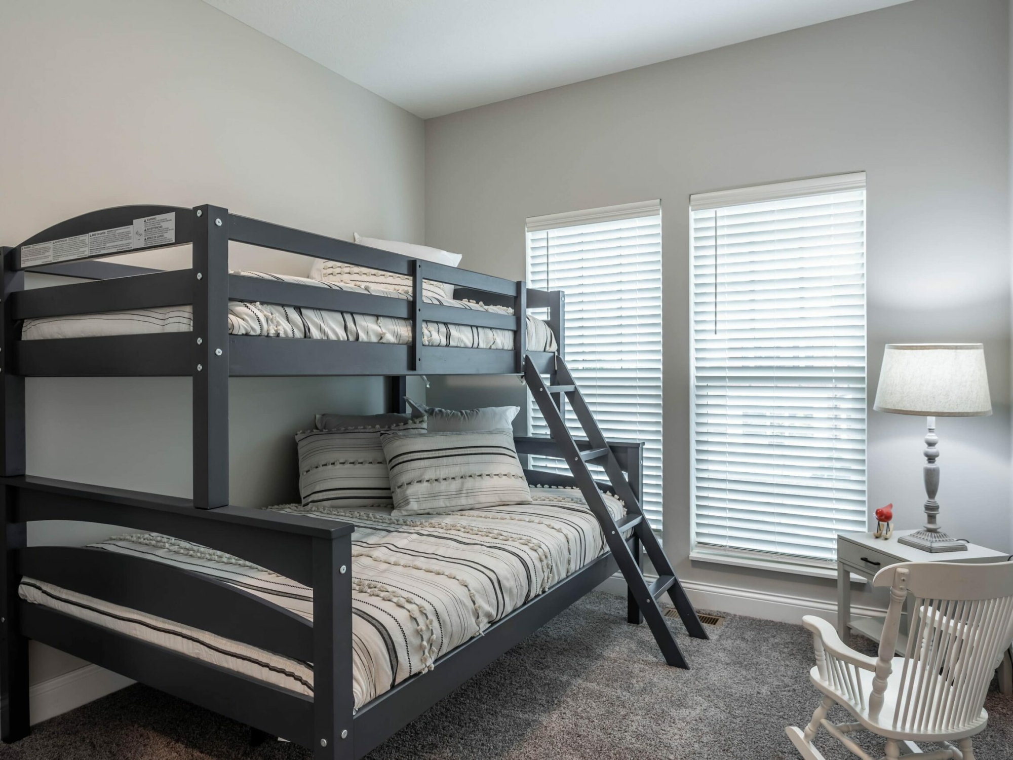 A bunk bed in a bedroom with a window.