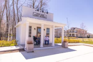 Two people sitting on a bench in front of a store.